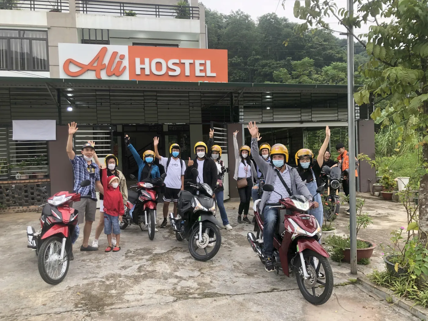 Guests and Ali riders waving in front of Ali Hostel in Ha Giang city before setting off on the loop