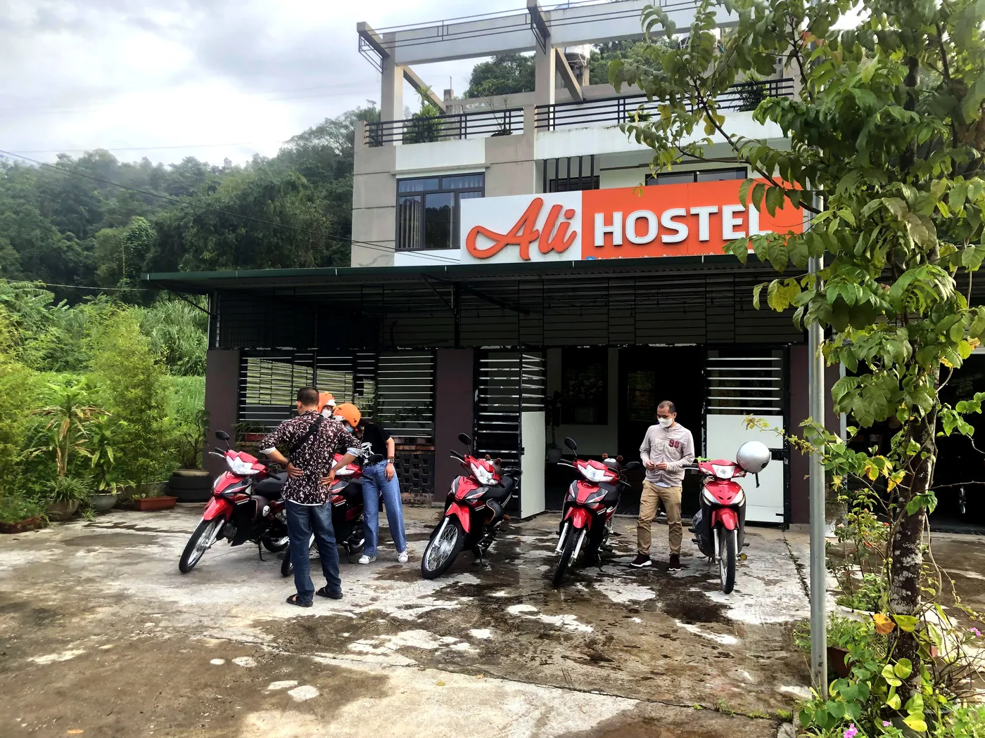 Motorbikes lined up and guests getting ready outside Ali Hostel in the morning