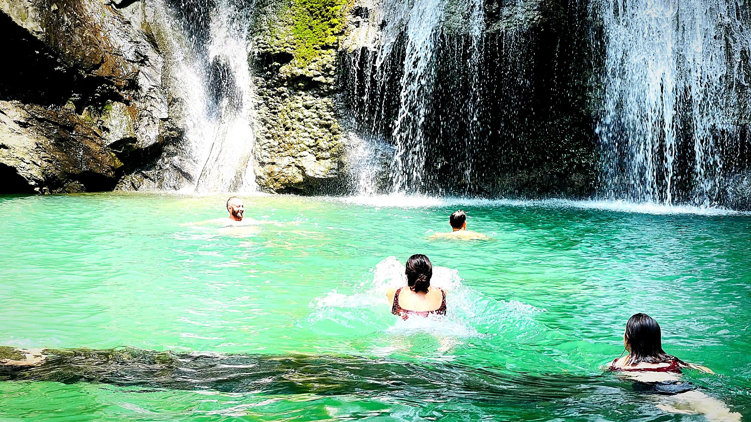 Guests swimming in the jade pool under Du Gia waterfall