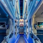 Cabin sleeper bus aisle with individual berths, screens and blue LED lighting