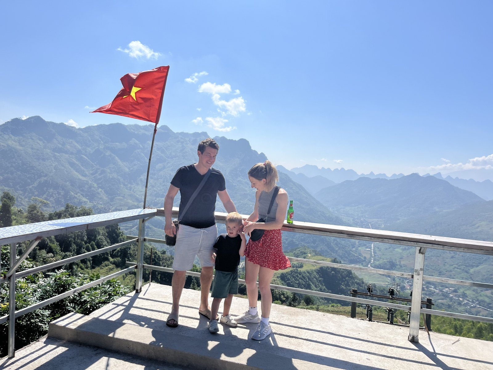 Ha Giang Loop with kids: a family at a flag viewpoint over the mountains