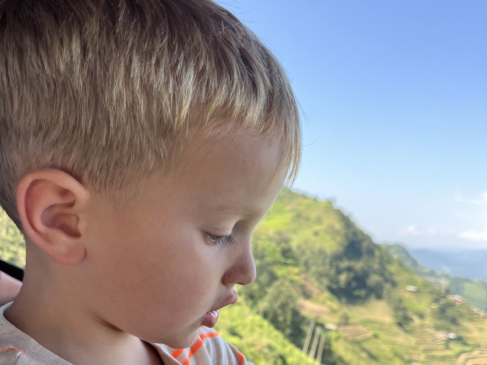 Ha Giang Loop with kids: a young boy looking at rice terraces from the car window