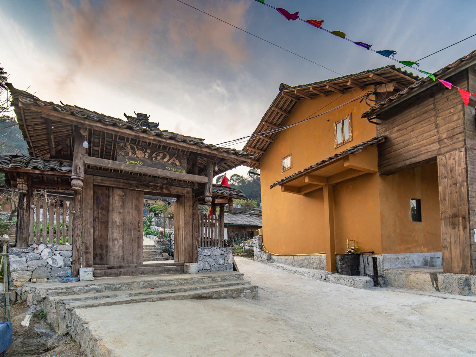 Wooden gate and rammed-earth house of a homestay in Lao Xa, Ha Giang