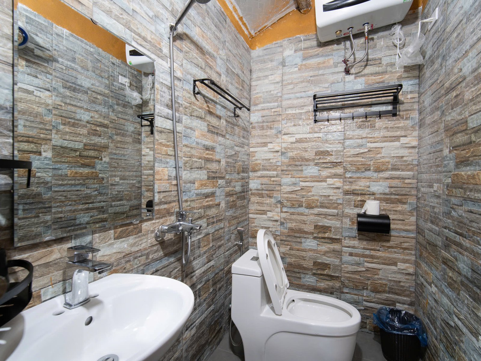 En-suite bathroom with shower and water heater at a Ha Giang homestay