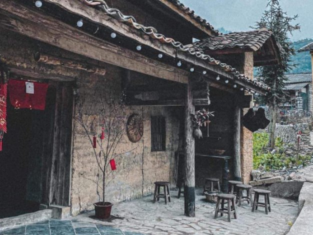Rammed-earth house in Lo Lo Chai village under a grey winter sky