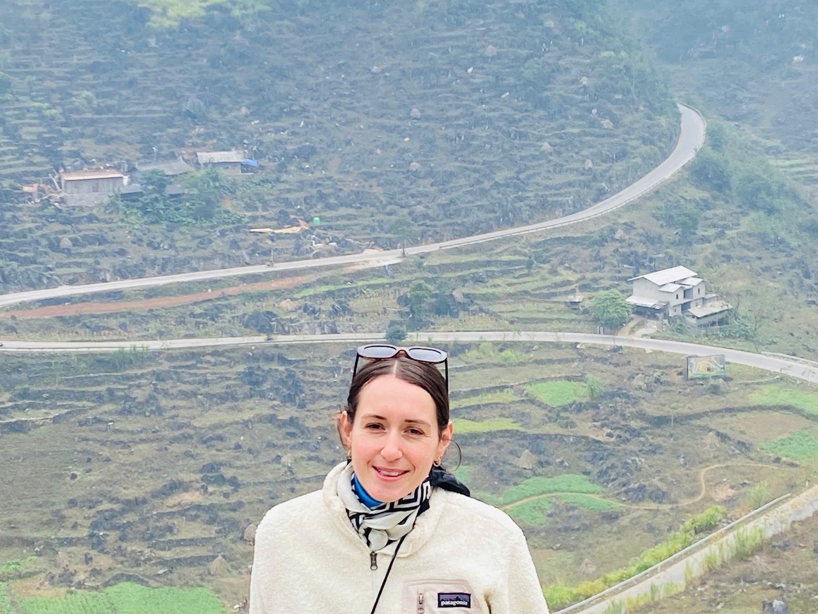 Ha Giang Loop in February: Tet, Blossoms and Drizzle (2027 Guide) 2 Guest in a fleece at the Quan Ba viewpoint on a hazy late-winter day on the Ha Giang Loop