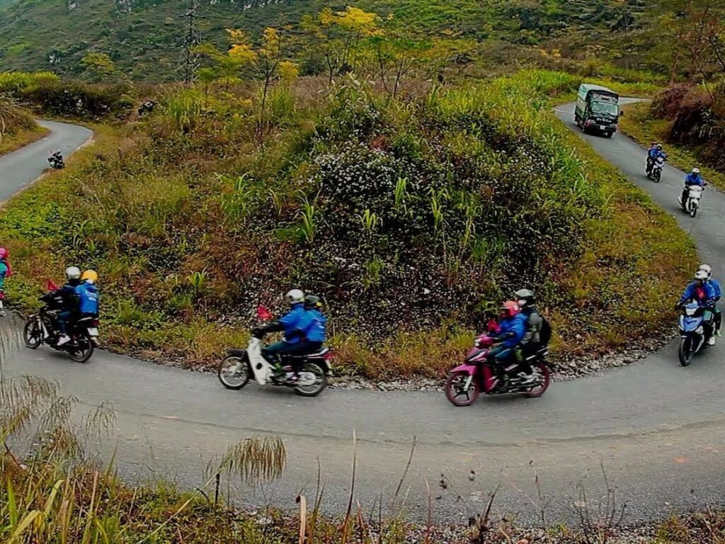 Riders in warm jackets on a hairpin bend, Ha Giang Loop in January