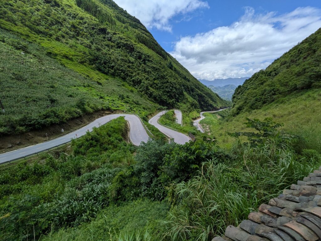 Ha Giang Loop in July: Should You Ride the Wettest Month? (2026 Guide) 1 Ha Giang Loop in July: a green mountain pass under summer cloud, photographed by Ali guests on 4 July 2026