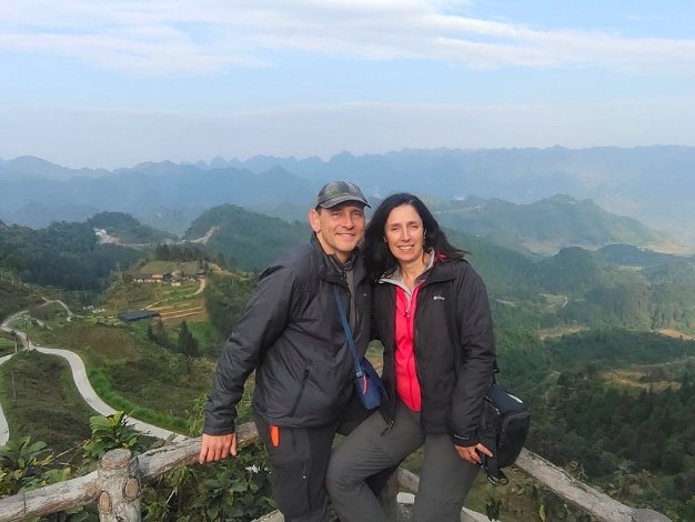 Ha Giang Loop private tour: a couple at a viewpoint above winding mountain roads