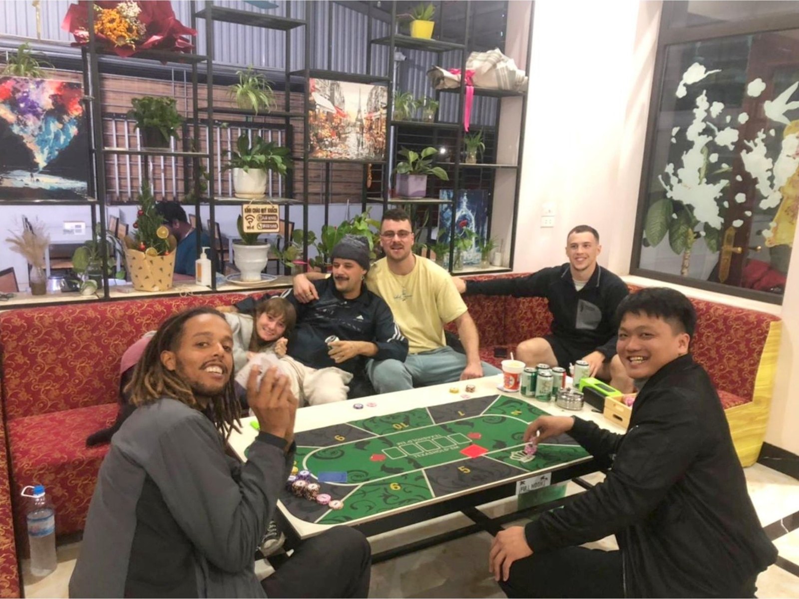 Group tour guests playing a board game with an Ali guide at Ali Hostel in the evening