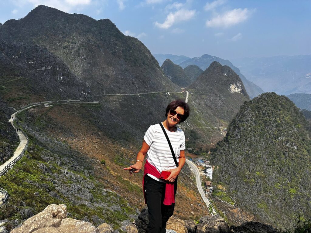 Ha Giang Loop solo traveller standing above the Ma Pi Leng Pass road