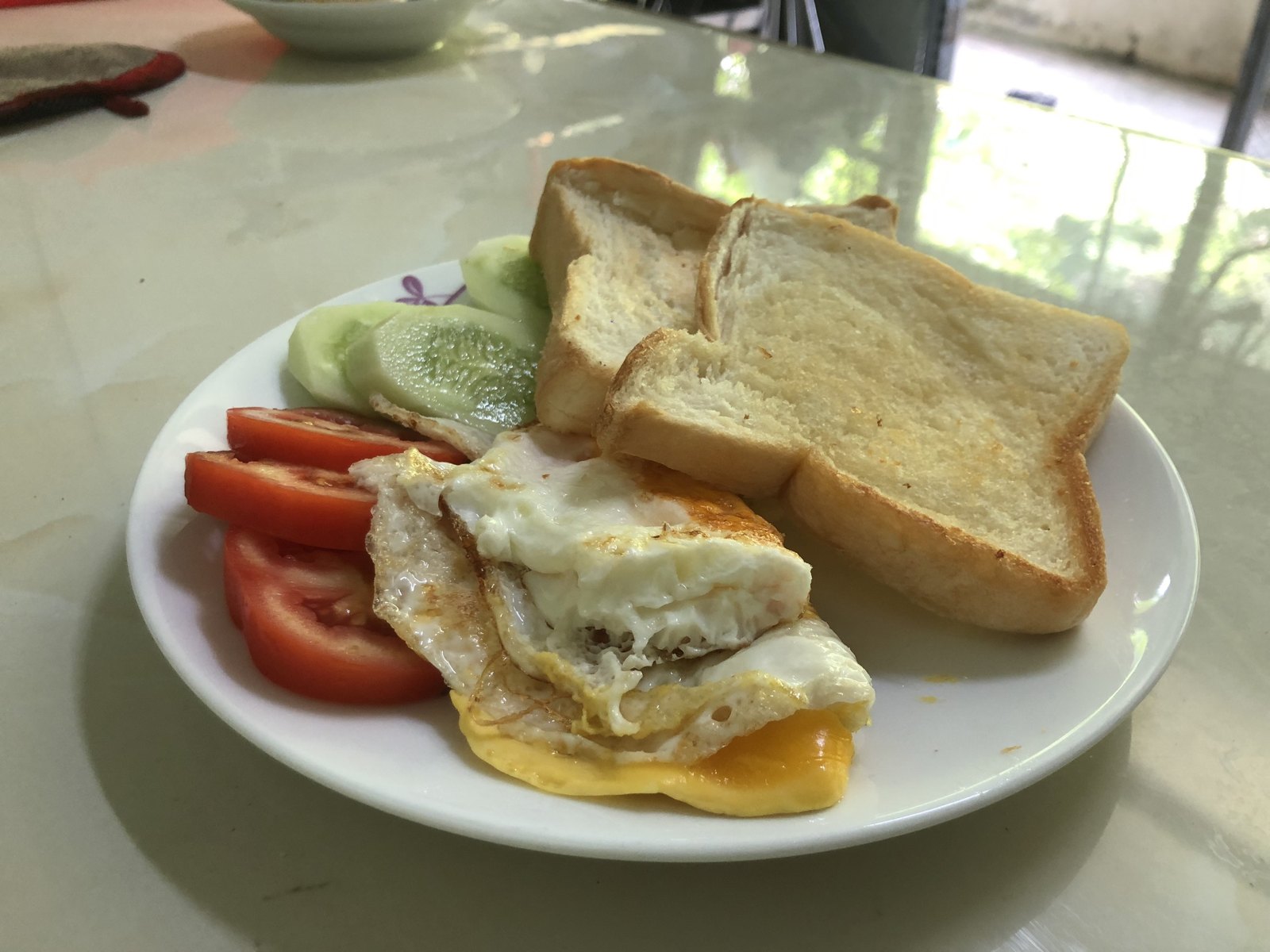 Fried eggs, toast, tomato and cucumber breakfast for a vegetarian in Ha Giang