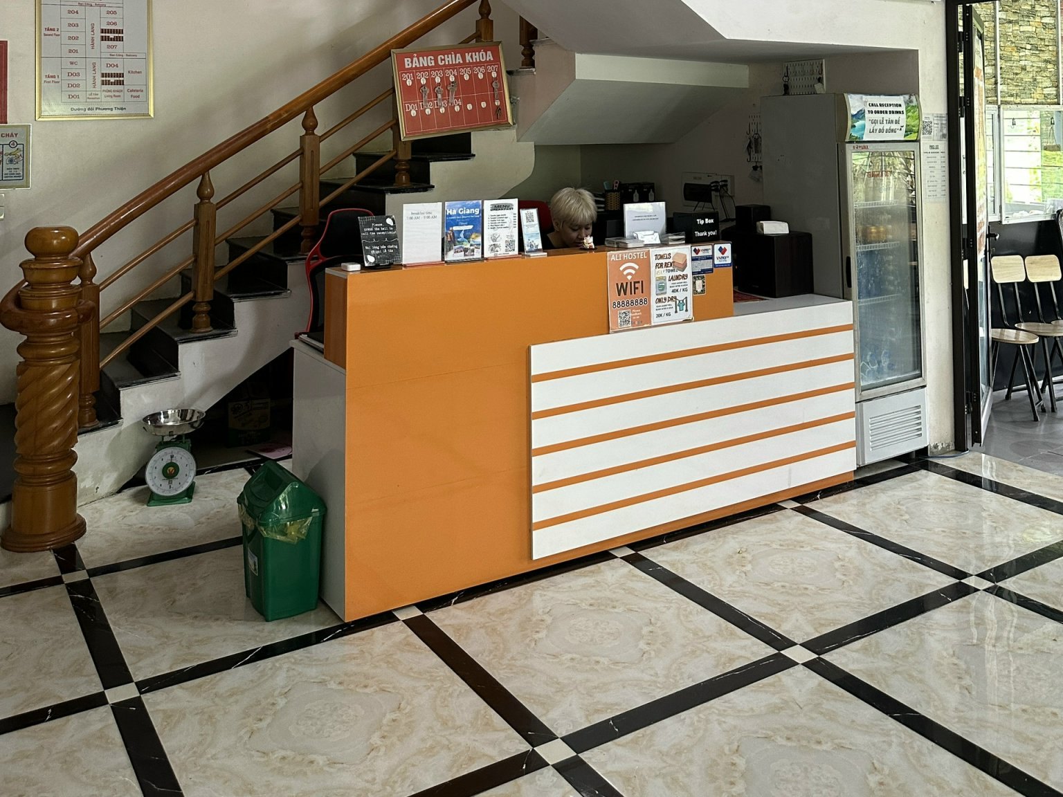 Reception desk at Ha Giang Ali Hostel where foreign guests show their passport and Ha Giang Loop visa at check-in