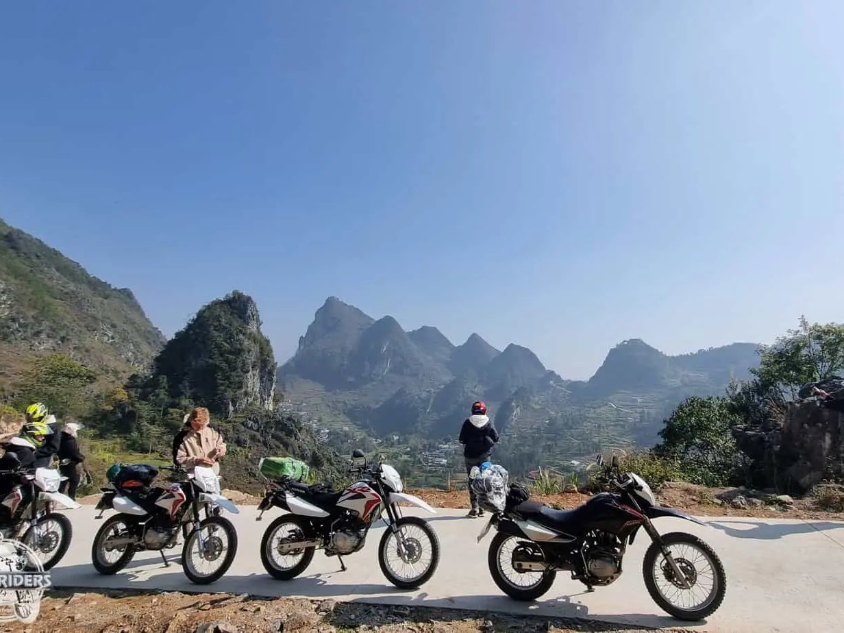 Riders with dirt bikes parked on the Ma Pi Leng road above the karst peaks of Ha Giang