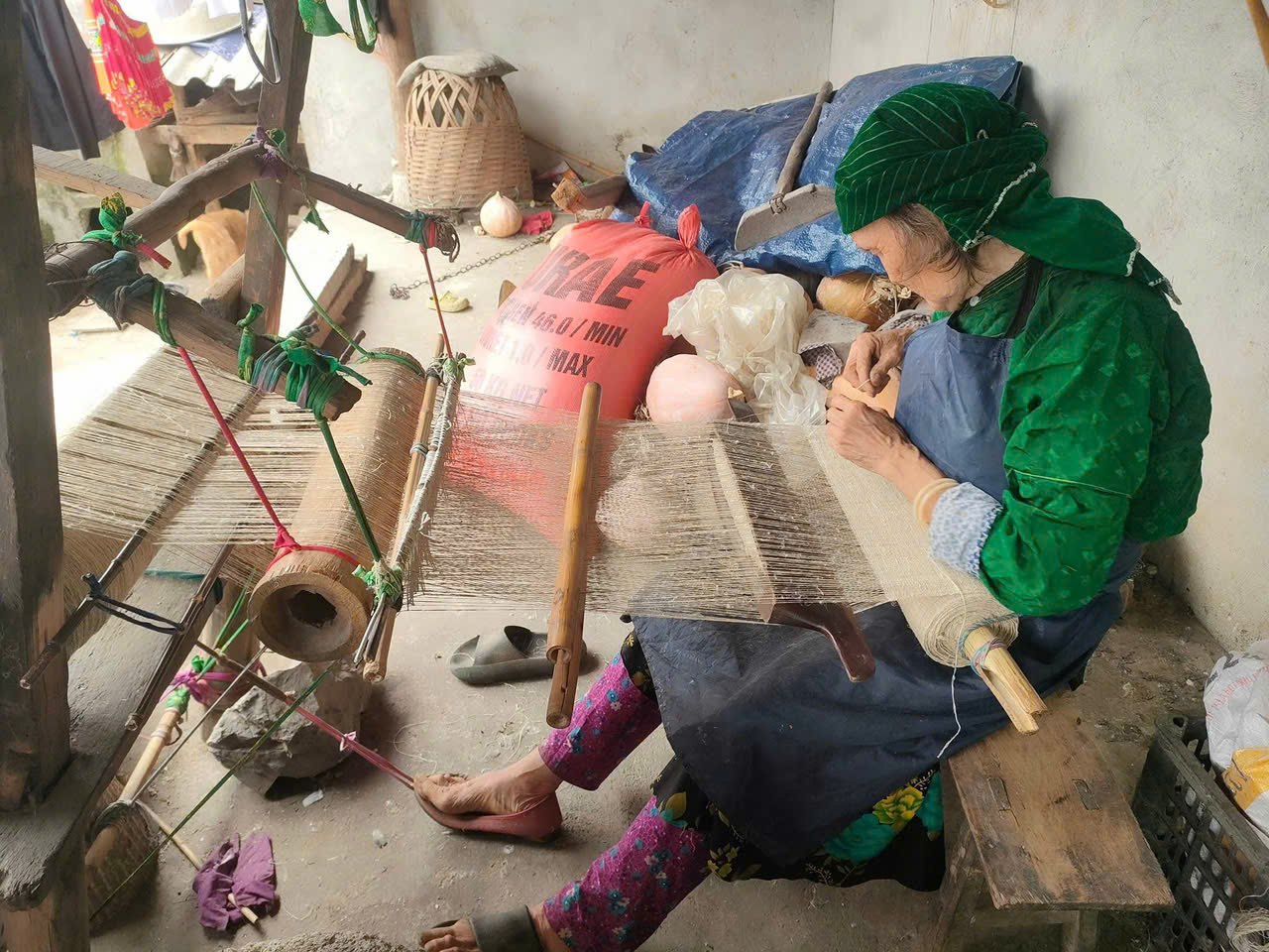 Is the Ha Giang Loop Worth It? An Honest Local Verdict (2026) 4 H'Mong woman weaving hemp on a wooden loom in Lung Tam village, Ha Giang
