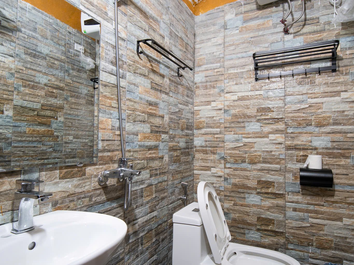En-suite bathroom with a hot-water heater at a Ha Giang Loop homestay